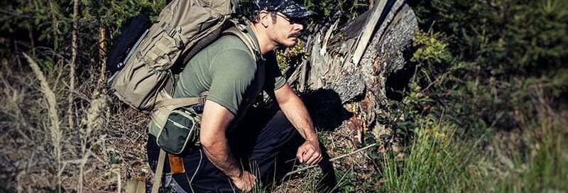 Ein-Wildnisfuehrer-kundschaftet-seine-Umgebung-im-Wald-aus