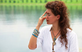 Frau macht in der Natur eine Atemübung Atemtechnik