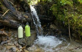 Wasserfall mit Trinkflaschen im Wald