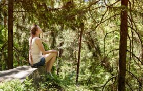 Frau-genießt-die-Luft-und-die-Bäume-im-Wald-Natur
