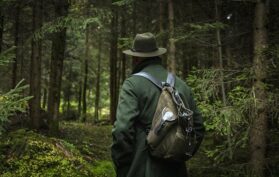 Jäger streift unauffällig und leise durch den Wald