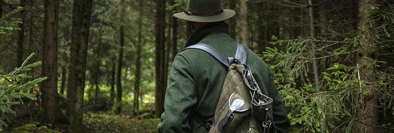 Jäger streift unauffällig und leise durch den Wald