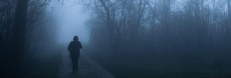 Wanderer orientiert sich im Wald in der Nacht